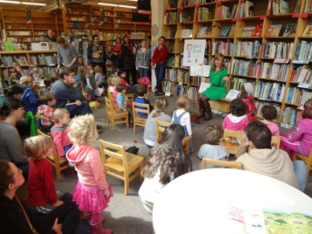 Children surrounding Author Katherine Pryor and learning about ''Slyvia's Spinach'cw'